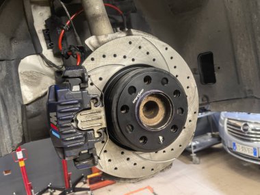 Milan, Italy 25 august 2024: Detailed view of a car's brake caliper and rotor, showcasing a performance upgrade. clipart