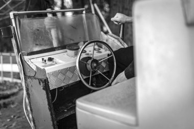 Eski, antika bir arabanın direksiyon ve kontrol panelinin monokrom görüntüsü, yaşını gösteriyor ve nostaljik bir ortamda giyiniyor..