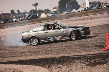 Villamarzana, İtalya 17 Eylül 2024: Gri BMW E36 Bir yarış sırasında bir yarış pistinde pürüzsüz bir şekilde sürükleniyor.