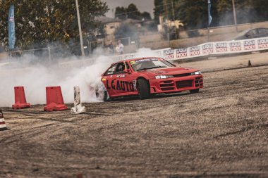 Villamarzana, Italy 17 September 2024: A red Nissan performs an intense drift on the track, tires smoking and the driver in control. clipart