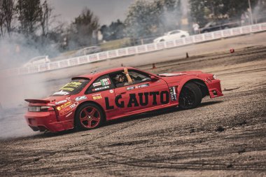 Villamarzana, İtalya 17 Eylül 2024: Kırmızı bir Nissan pistte yoğun bir kayma gerçekleştiriyor, sigara içen lastikler ve kontrollü sürücü.