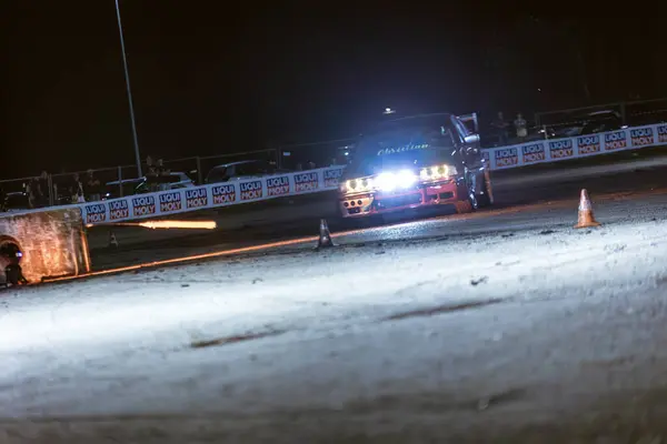 stock image Villamarzana, Italy 17 September 2024: A blue drift car takes a sharp turn on the track at a night event, drifting around traffic cones with precision.