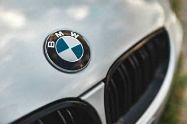 Milan, İtalya 4 Ekim 2024: İkonik bmw logosu gümüş bir arabanın kaputuna ışığı yansıtıyor