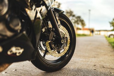 Milan, İtalya 4 Ekim 2024: Kaldırımda park etmiş bir spor motosikletinin ön tekerleğini ön plana çıkaran yakın çekim