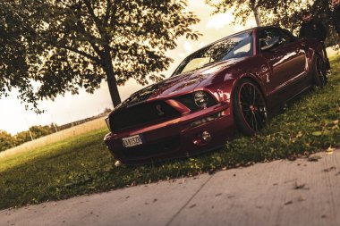 Milan, İtalya 4 Ekim 2024: Kırmızı bir Ford Mustang Shelby gt500, arka planda bulanık bir figürle yol kenarına park edilmiştir.