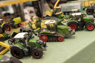 Milan, Italy 8 October 2024: Detailed model tractors are displayed on a table at an agricultural exhibition, showcasing the latest in farming technology clipart