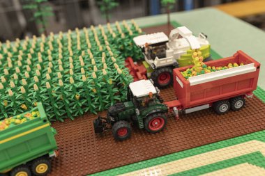 Milan, İtalya 8 Ekim 2024: Bir tarım fuarında lego traktörleri ve karavanlar tarafından minyatür bir mısır tarlası hasat ediliyor