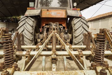 Verona, İtalya 17 Ekim 2024: Rusty Cultivator Hitch eski bir fiat traktörünün altında, tarlada kullanılmayı bekliyor