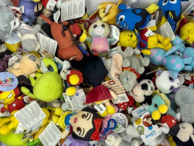 Verona, İtalya 17 Ekim 2024: Bir oyuncakçıdan satın alınmayı bekleyen popüler çizgi film karakterlerinin yer aldığı renkli pelüş oyuncaklar yığını