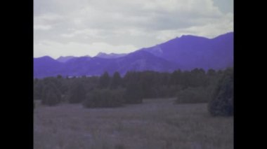 Austin, ABD Mayıs 1975: Colorado 'daki tanrıların bahçesinin yüksek kızıl kaya oluşumları arasında yürüyen turistler