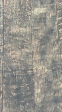 Kamera yavaş yavaş sağa hareket ediyor, ahşap bir desen ortaya çıkarıyor.