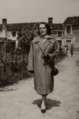 Roma, İtalya 1964 olabilir: 1960 'ların moda ve kırsal yaşamını gözler önüne seren şık bir Fransız köyünde gezen şık bir kadını gösteren klasik siyah beyaz fotoğraf