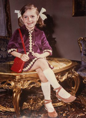 Roma, İtalya 1964: 1960 'lardan kalma eski moda kıyafetlerle lüks bir masada oturan genç kız