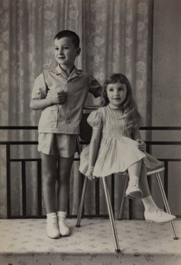 Roma, İtalya 1964 olabilir: İyi giyimli bir erkek ve kız kardeşin 1960 'ların ve 1970' lerin masumiyetini ve modasını yakalayarak birlikte poz verdiği klasik siyah beyaz fotoğraf