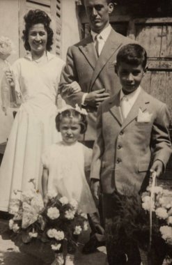 Roma, İtalya 1964: Aile şık giyinmiş, elinde buketler, 1960 'larda resmi bir portre için poz veriyor
