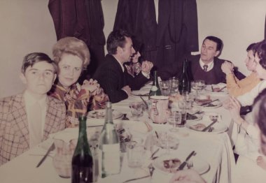 Roma, İtalya 1964 'te olabilir: Aile ve arkadaşlar bir masanın etrafında toplanıyor, muhtemelen 1960 veya 1970' lerden kalma klasik bir ortamda birlikte yemek yiyorlar