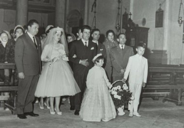 Roma, İtalya 1964: Gelin ve damat, bu klasik siyah beyaz fotoğrafta çiçek kız, aile ve arkadaşlarıyla kiliseden ayrılıyor