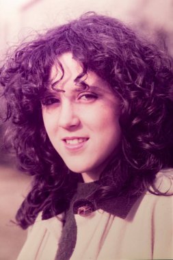 Roma, İtalya 1964: 1970 'lerden kalma eski bir portre fotoğrafında gülümseyen kıvırcık saçlı genç kadın