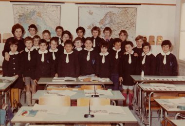 Roma, İtalya 1964: Bir grup üniformalı ilkokul öğrencisinin ve öğretmenlerinin İtalya ve Avrupa haritaları önünde poz verdikleri klasik sınıf sahnesi