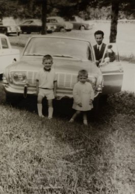 Roma, İtalya 1964: Bir işadamı, iki çocuk ve klasik arabalarının yer aldığı aile portresi, 1960 veya 1970 'lerden bir anı yakalıyor