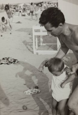 Roma, İtalya 1964: Baba ve oğlunun 60 'lı ya da 70' li yıllardaki yaz tatillerinde plajda oynadığı klasik fotoğraf