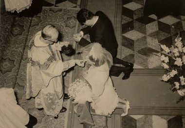 Roma, İtalya 1964 'te olabilir: Bir düğün töreninin klasik siyah beyaz fotoğrafı, gelin ve damadın mihrapta diz çökmesi, bir rahipten komünyon alması