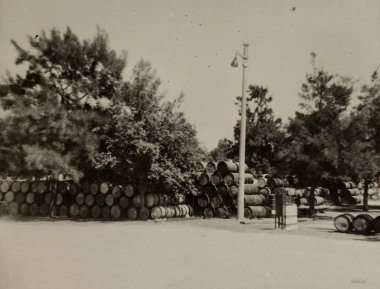 Roma, İtalya 1964 yılına ait olabilir: 1960 'larda veya 1970' lerde, muhtemelen bir depolama tesisi veya sanayi bölgesi yakınlarında, açık hava yığınları halinde yığılmış sayısız ahşap varilleri gösteren klasik fotoğraf