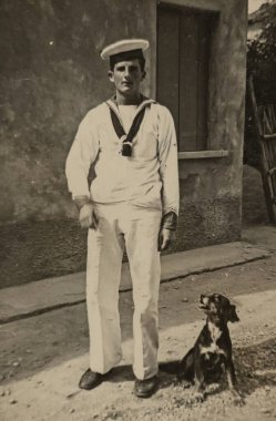 Roma, İtalya 1964: Tarihsel monokrom görüntüsü, genç bir denizcinin köpeğiyle gururla durduğu, 1960 ya da 1970 'lerden bir anı yakaladığı