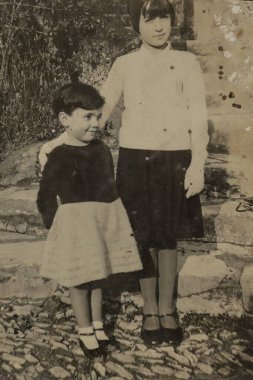 Roma, İtalya 1965 'te olabilir: İki çocuk, bir erkek ve bir kız, 1960 ya da 1970' lerde çekilmiş siyah beyaz bir klasik fotoğrafta birlikte poz veriyorlar, zamansız çocukluk arkadaşlığı duygusu yayıyorlar.