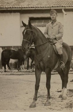 Roma, İtalya 1965 'te: Bir ata bindirilmiş, muhtemelen askeri bir ahır veya eğitim alanında üniformalı bir askeri resmeden klasik siyah beyaz fotoğraf