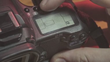 Fotoğrafçı, bir dslr kameradaki ayarları ayarlıyor