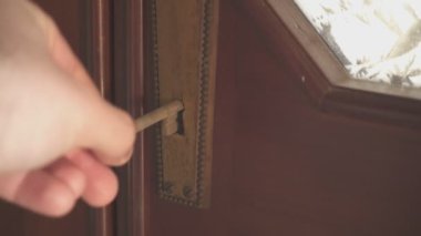 Adam yıpranmış ahşap kapıyı açıyor ve açıyor.