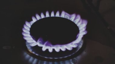 Gaz ocağı yanıyor, mor bir alevle yanıyor ve yanıyor.