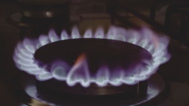Gaz sobası canlı mavi bir alevle yanıyor. Enerji tüketimi ve ısı üretimini gösteriyor.
