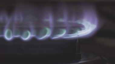 Gaz ocağı alev alıyor ve canlı alevler üretiyor. Mutfak ortamında yanmanın güzelliğini gösteriyor.