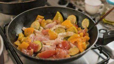 Aşçı, ahşap mutfak malzemelerini kızartma tavasında karıştırıyor.