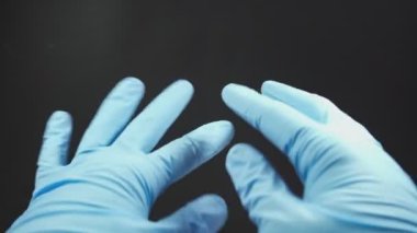 Doktor ya da hemşire mavi nitril eldiven giyerken çeşitli el hareketleri gösteriyor.