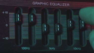 Ses mühendisi bir grafik eşitleyicinin düğmelerini ayarlar