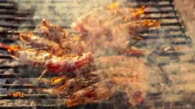 Şef lokantada misafirler için ızgara karides pişirirken duman yükseliyor.