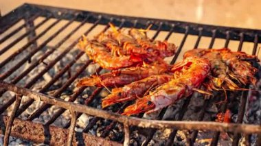 Lokantadaki müşteriler için bir şef tarafından ızgarada kızartılan birkaç kaplan karidesi.