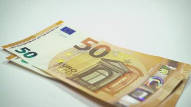 Beyaz arka planda 50 ve 100 banknotluk Avro banknotları bulunuyor