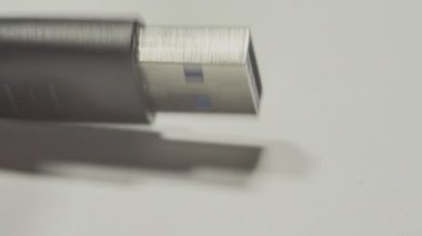 Teknisyen beyaz arka planda bir USB 3.0 kablosu tutuyor.