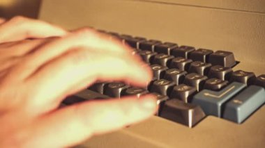 Nostaljik bir ofis ortamında klasik bir bilgisayar klavyesine yazı yazan ellerin yakın çekimi. Geçmişten kalma teknolojinin altını çizmek