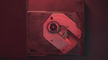 Teknisyen, kırmızı ışıkla aydınlatılmış bir bilgisayar sürücüsüne cd-rom yerleştiriyor.