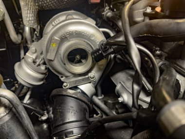 Ferrara, İtalya 18 Aralık 2024: Bir Garrett turbo şarj cihazının yakın çekimi modern bir otomobil motoruna entegre edilmiş, güç ve verimliliği artırıyor