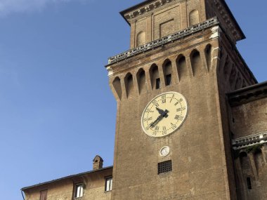 İtalya, Ferrara 'da, berrak mavi gökyüzüne yükselen Castello saat kulesi, zamanın geçişini işaret ediyor.