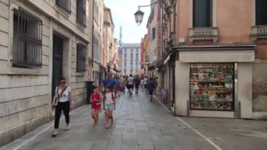 Venedik, İtalya 1 Ocak 2025: Turistler ve yerliler Venedik, İtalya 'da dükkan ve restoranlarla dolu dar bir sokakta yürüyorlar