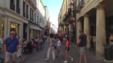 Padova, İtalya 1 Ocak 2025: Padua, İtalya 'da kalabalık bir kaldırım taşı caddesi boyunca yürüyen insanlar, yol boyunca mağazalar ve kafeler çizerek canlı şehir yaşamını gözler önüne seriyor
