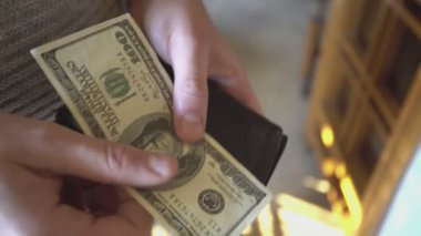 Milan, İtalya 1 Ocak 2025: Adam 100 dolarlık banknotları sayıyor