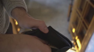 Milan, İtalya 1 Ocak 2025: Adam 50 avroluk banknotları sayıp cüzdanına koyuyor